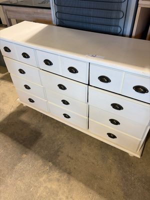 an image of a white dresser with black knobs in a room
