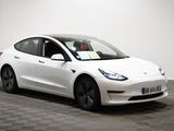 an image of a white tesla model 3 parked in a showroom
