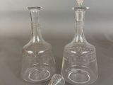 pair of clear glass decanters on a gray surface