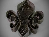 a metal object with holes on it on a white surface