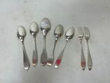 five spoons and a fork on a table