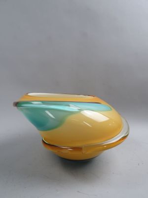 un saladier jaune et bleu posé sur une table blanche