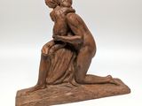 a statue of a woman sitting on a rock with her head in her hands