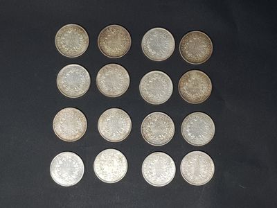 a lot of silver coins on a black surface