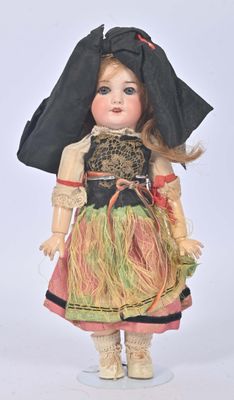 une poupée qui porte un chapeau et une robe noirs