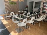 tables and chairs are set up in a restaurant with a wooden wall