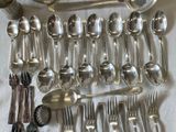 a lot of silver spoons and spoons on the table