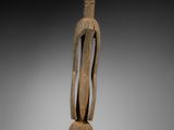 une image représentant une sculpture en bois d'un homme au long cou