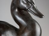 statue of a duck on a pedestal against a gray background