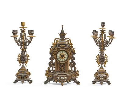 GARNITURE DE CHEMINÉE en métal d'aspect argenté et doré. Ell…