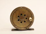 a small metal object on a stand on a white surface
