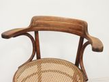 a wooden chair with a woven seat on a white floor
