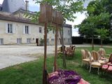 many chairs and tables in the grass outside of a building