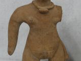 a small statue of a woman and a vase on a table