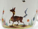une tasse à café sur laquelle sont représentés un cheval et un oiseau