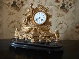 une horloge en or posée sur une table noire