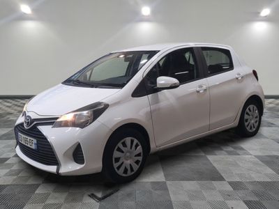 la toyota yaris blanche est garée sur un carrelage à carreaux