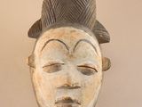 an image of a wooden mask hanging on a wall