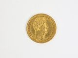 gros plan d'une pièce d'or sur une surface blanche