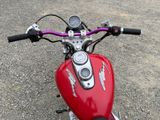 a close up of a red motorcycle parked in a parking lot