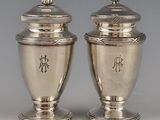 pair of silver vases with chinese writing on them on a table