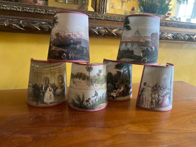 cinq tasses ornées de photos de personnes, posées sur une table