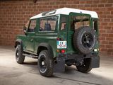 a green and white land rover parked in front of a brick wall