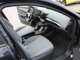 the interior of a car with the door open and the driver ' s seat down