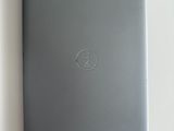 ordinateur portable posé sur une surface blanche, avec le logo Dell sur l'écran