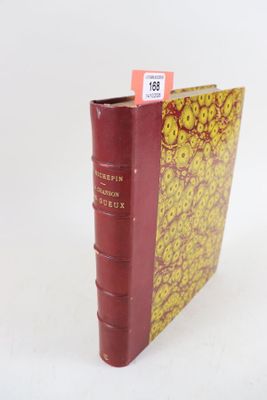 un livre rouge à la couverture jaune posé sur une surface blanche