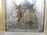 une image représentant une plaque métallique argentée sur laquelle figure un ange tenant un livre