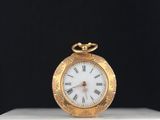 une image d'une montre de poche en or avec des chiffres romains sur le cadran