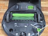 a black and green robot that is sitting on a wooden floor