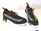 baskets à carreaux noirs et blancs avec des touches orange sur fond blanc