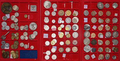 many different types of coins in a red display case
