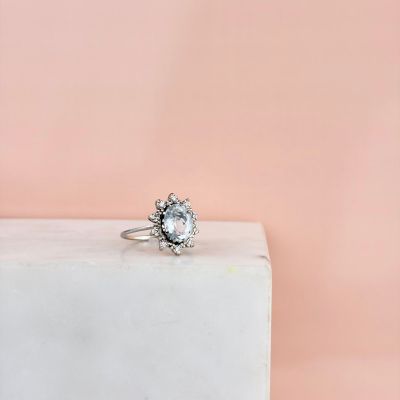 a close up of a white diamond ring sitting on a marble block