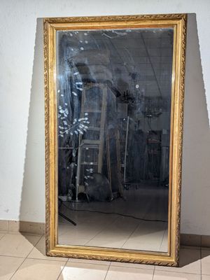 un grand miroir posé sur le sol d'une pièce