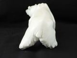 a white polar bear figurine on a black background