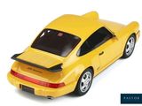 a yellow toy car that is sitting on a white surface