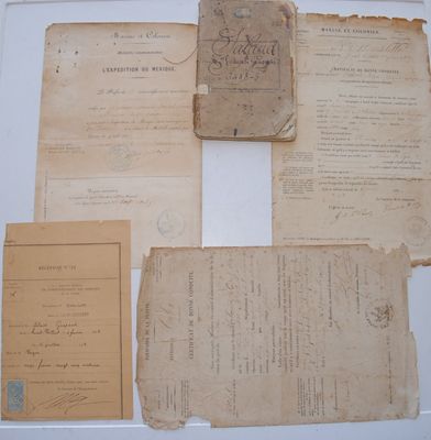 quelques vieux papiers sont posés sur une table blanche