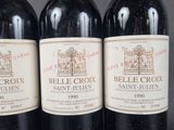 three bottles of red wine are lined up on a table