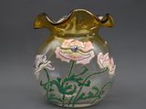 un vase en verre sur lequel sont peintes des fleurs, sur un fond gris