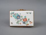 a small white and blue flowered box with gold trim