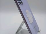 the back of a purple phone with a metal stand on a white surface