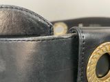 a black leather belt with a gold buckle on it