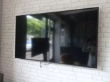 un grand téléviseur à écran plat fixé à un mur de briques