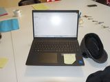a laptop computer sitting on a table with a hat on top of it