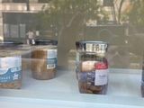 several jars of food sit on a window sill in front of a building
