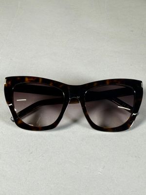 lunettes de soleil « œil de chat » noires et écaille sur un fond blanc