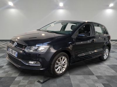 the black volkswagen polo is parked on a checkered tile floor